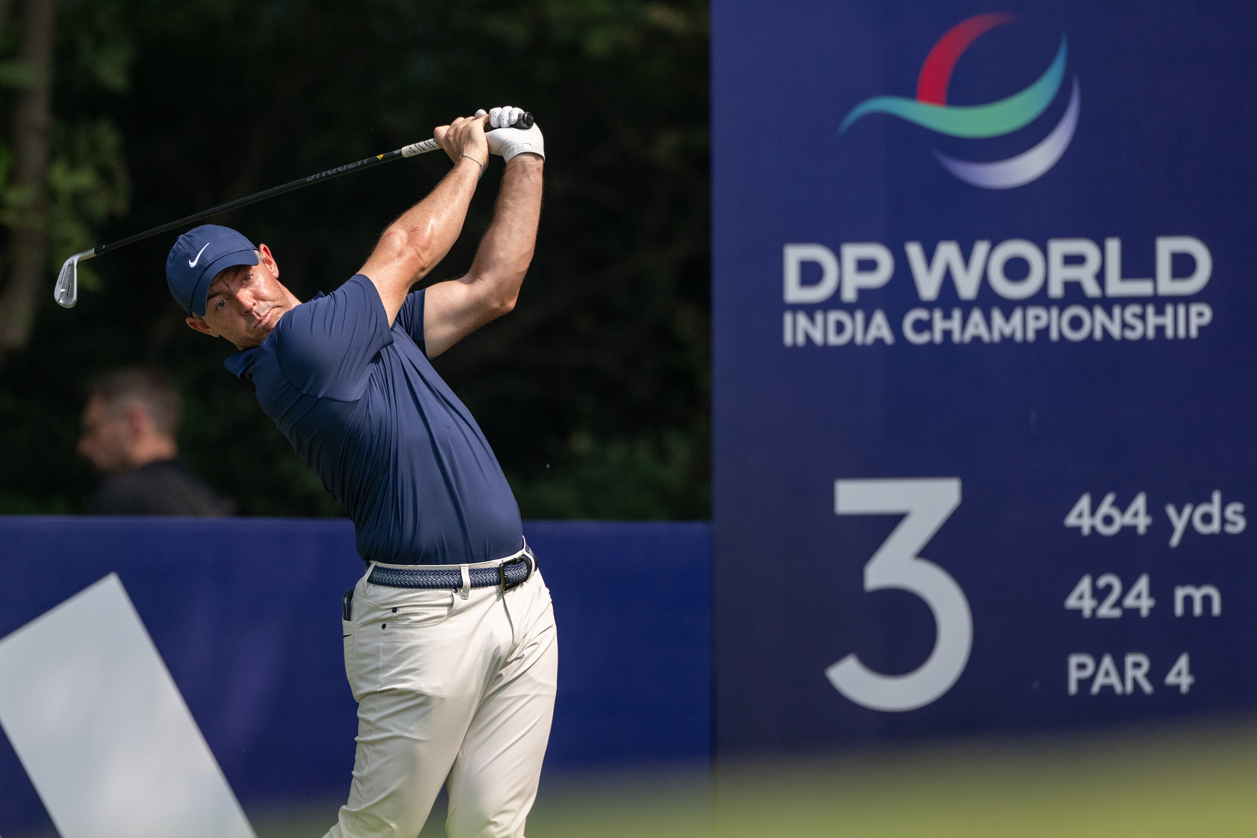 Rory McIlroy hits a tee shot in front of an advertising board