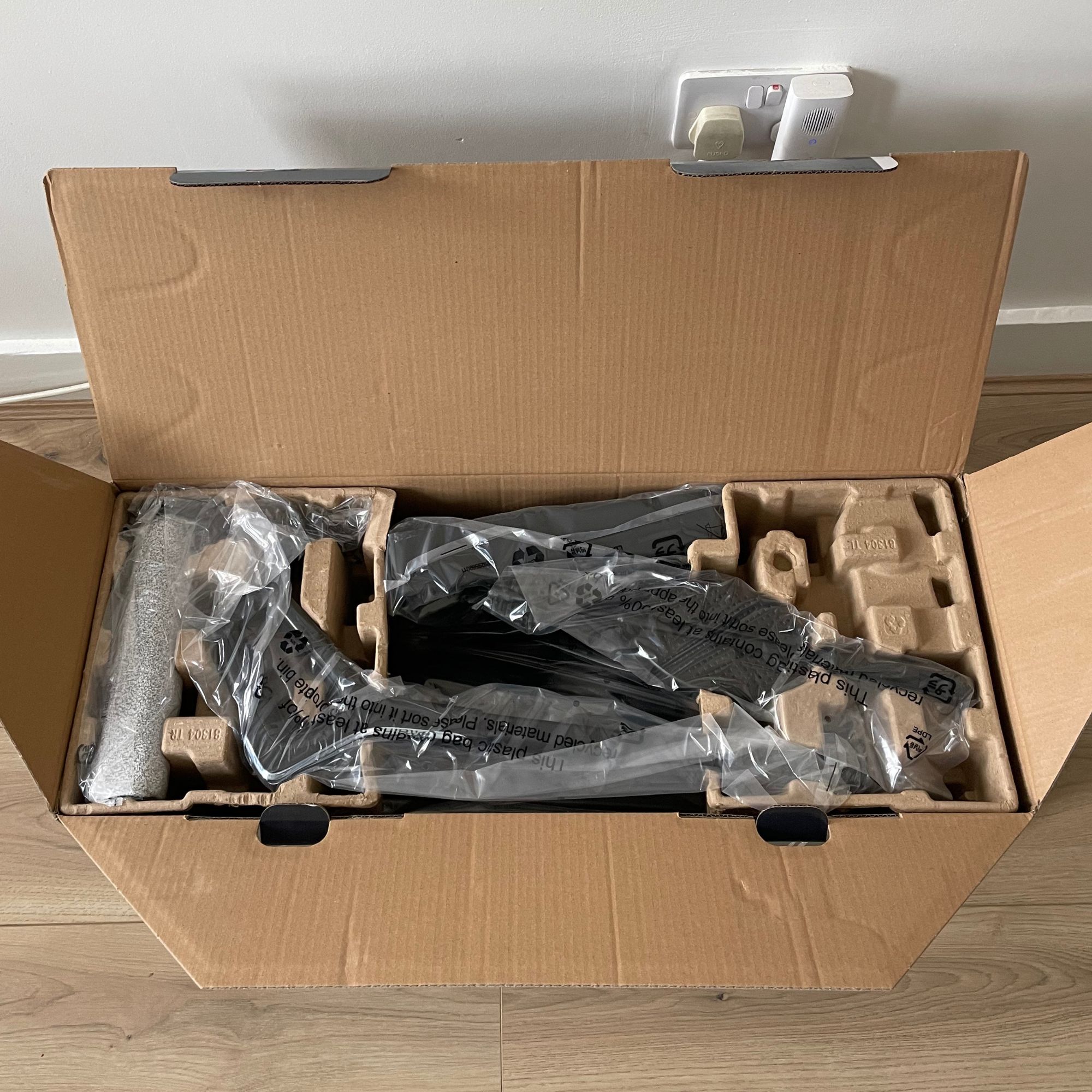 Tefal X-CLEAN 4 vacuum mop box opened with components wrapped in plastic inside