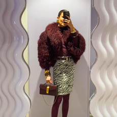 Nina Sandbech in a burgundy faux fur jacket, bag, and tights with a zebra print skirt.