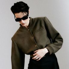 H&M green shoulder-pad jacket with a black pencil skirt and sunglasses