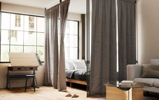 bedroom with bed zoned off from rest of room using curtain rod and pole system