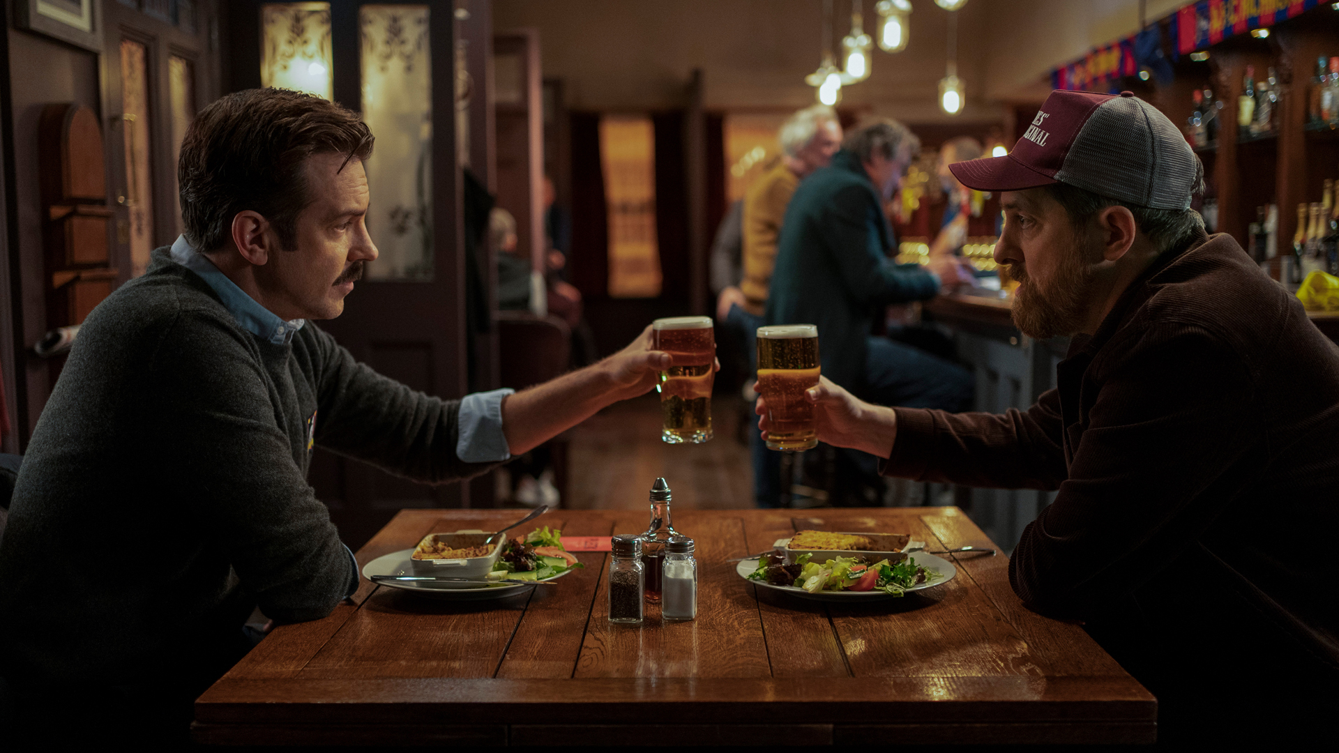 Ted Lasso and Coach Beard share a meal and drink in Ted Lasso season 2