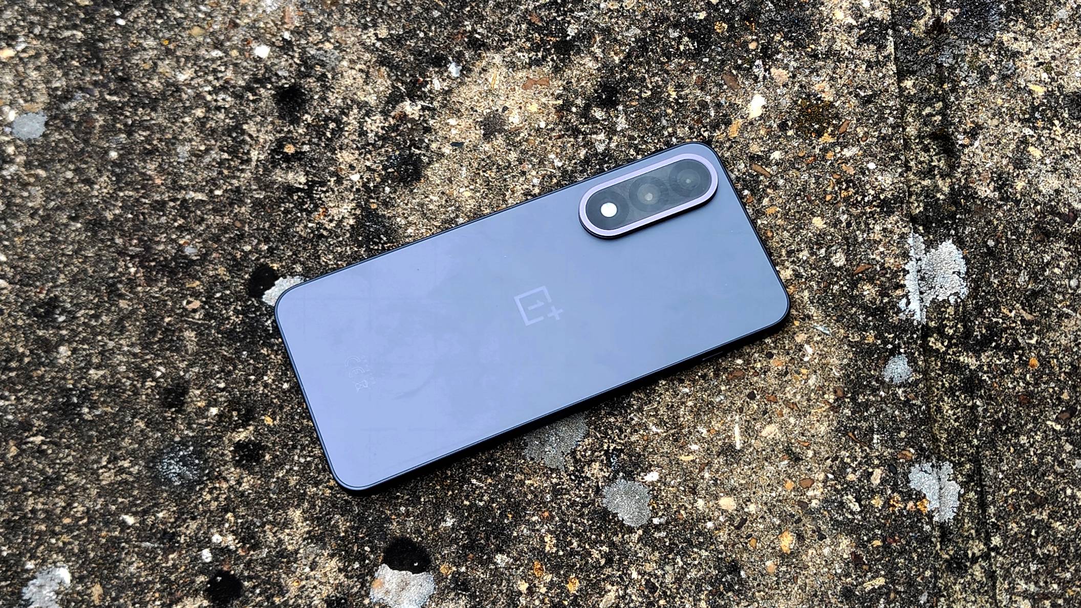 The OnePlus Nord 5 lying on a brick wall.