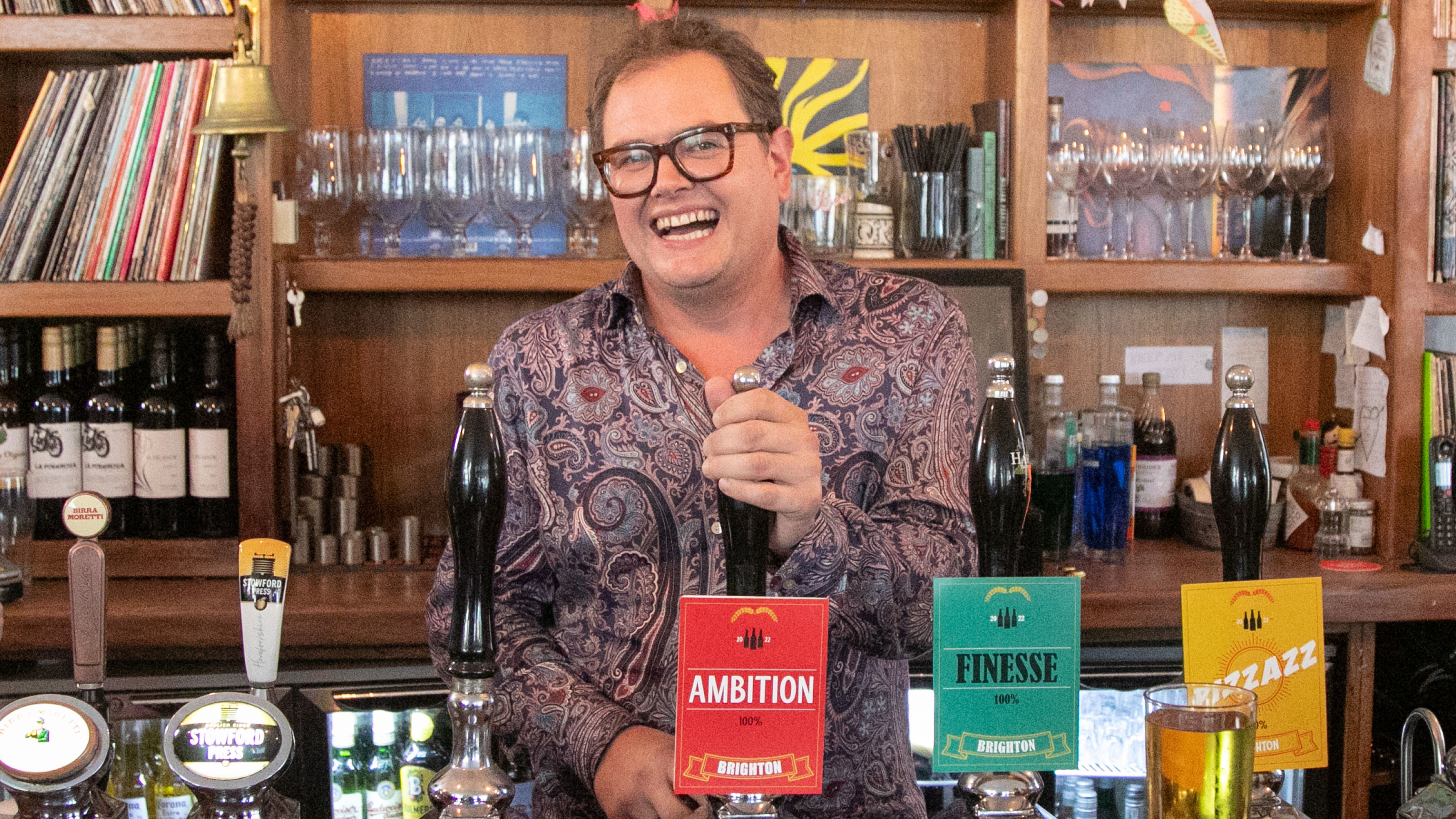 Alan Carr pulls a pint in a bar for Interior Design Masters
