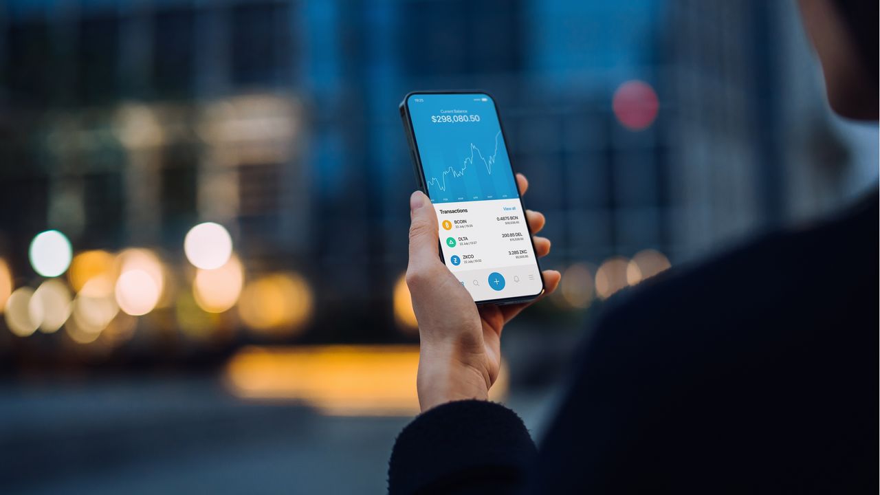 A man looks at stock prices on his smartphone.