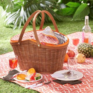 4 person wicker picnic basket with fruit and juice set up on grass