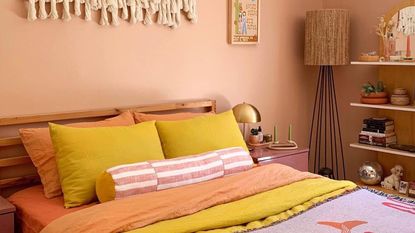 A peach-colored room with a colorful bed