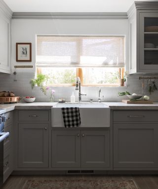 small grey kitchen with brass hooks by Innen Studio