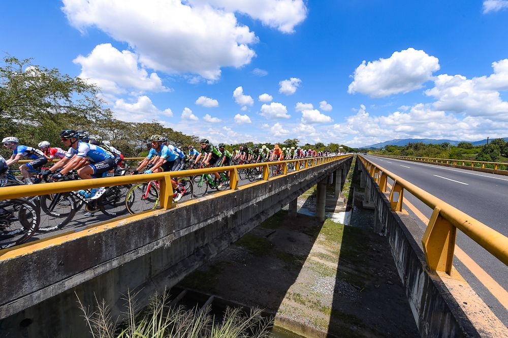 The peloton passes a bridge during stage 3 at Colombia Oro y Paz