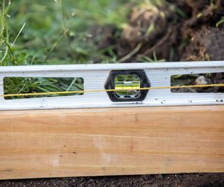 Close up of a spirit level outside in a garden levelling a space