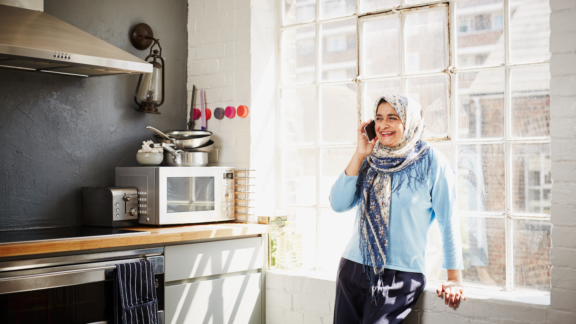 Woman talking on phone in kitchen