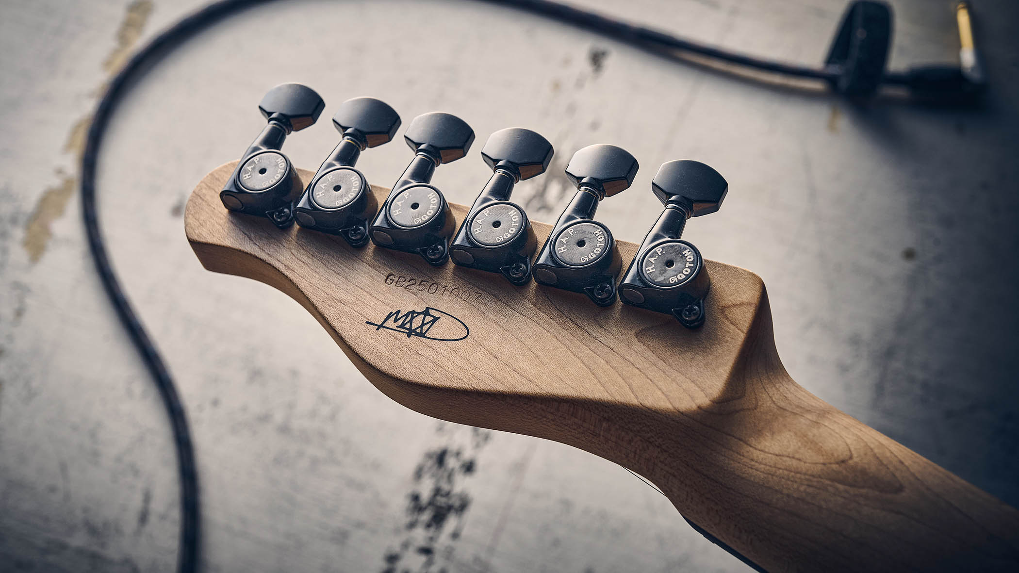 Manson MD-3 Mikey Demus Signature: the hot-orange T-style is photographed against a distressed grey-white background