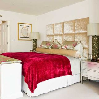bedroom with white wall and cream velvet headboard