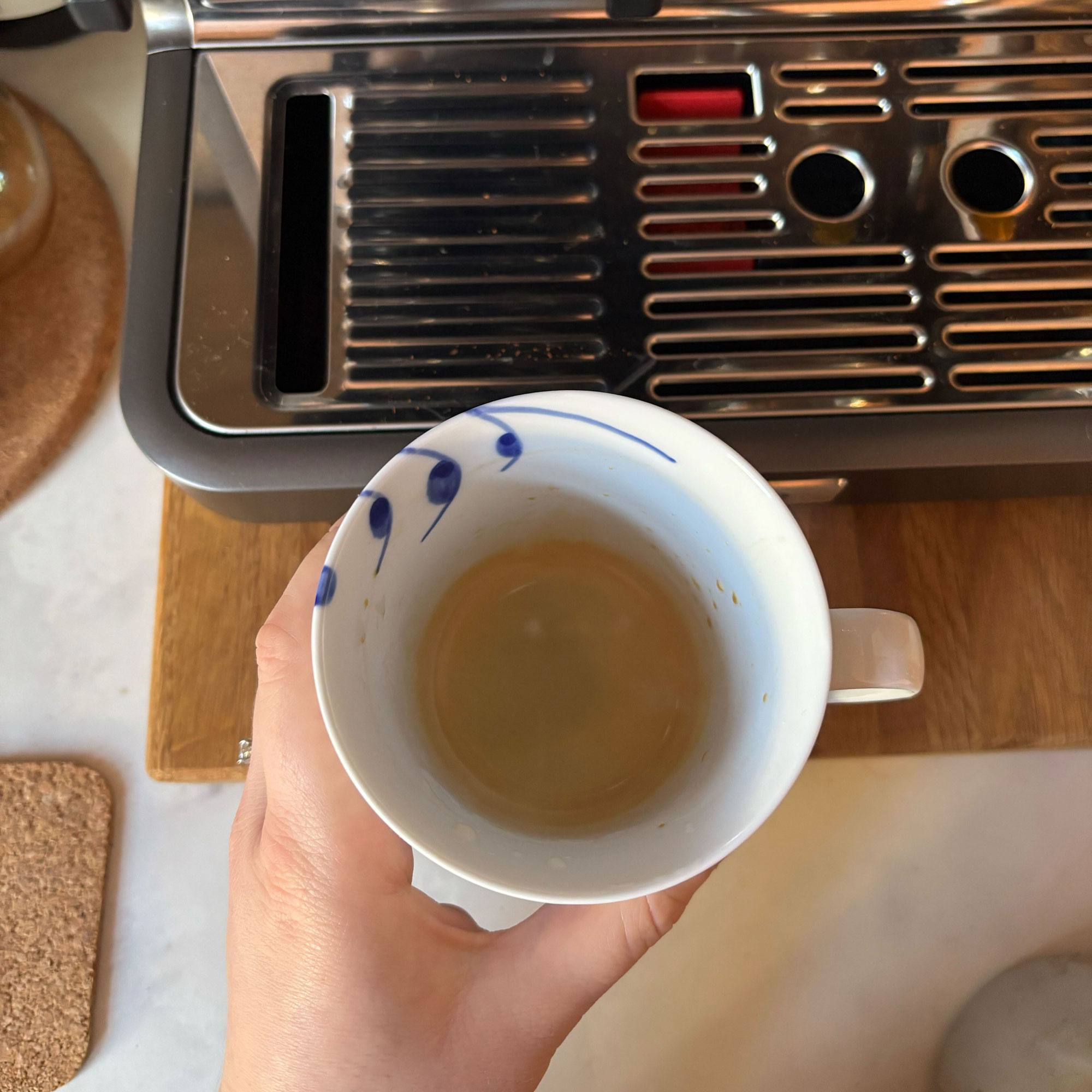 A single shot of espresso in a blue and white mug