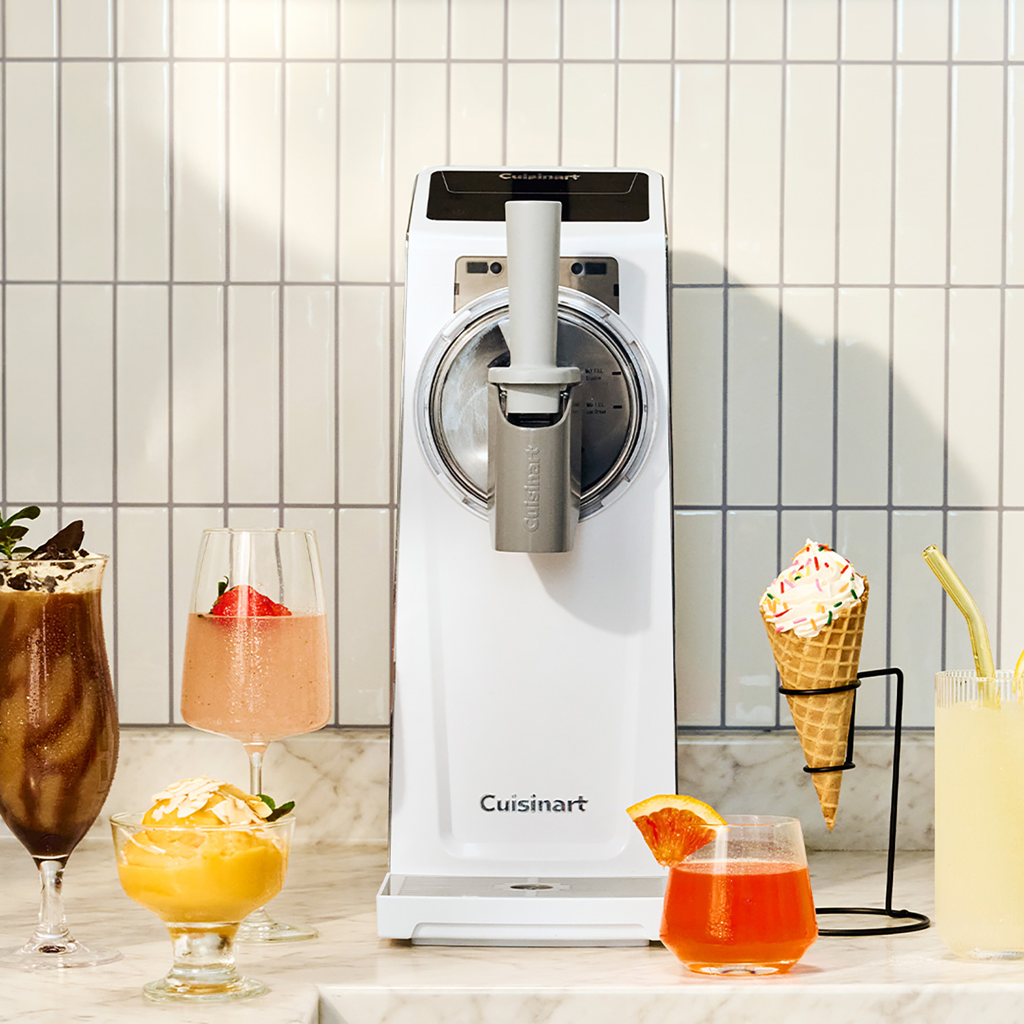 Cuisinart slushie and soft serve machine with various drinks and ice creams around it in a promotional image