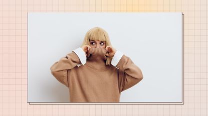 a woman wearing a brown high-neck sweater and pulling it up over her nose