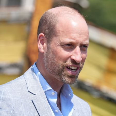 Prince William wearing a light gray suit and blue shirt 