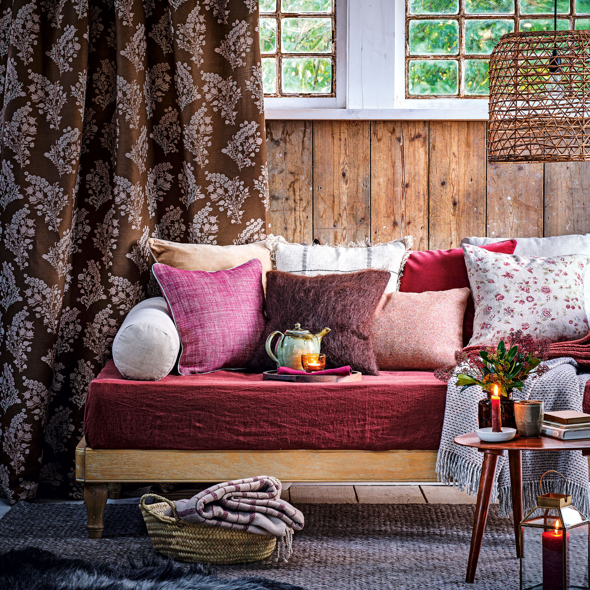 Purple cushions on a day bed with wooden wall panelling and grey carpet