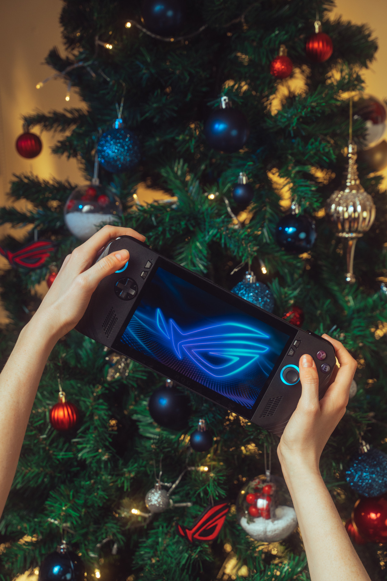 ROG Ally X y de fondo un árbol navideño