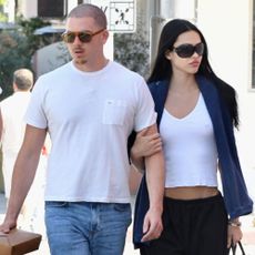 Amelia Grey Hamlin wears long shorts with a white tank top and black loafers.