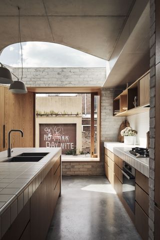 Kitchen with tiled worktop by Andrew Burges Architects