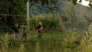A screenshot showing characters walking through a field from A Quiet Place Part II cast
