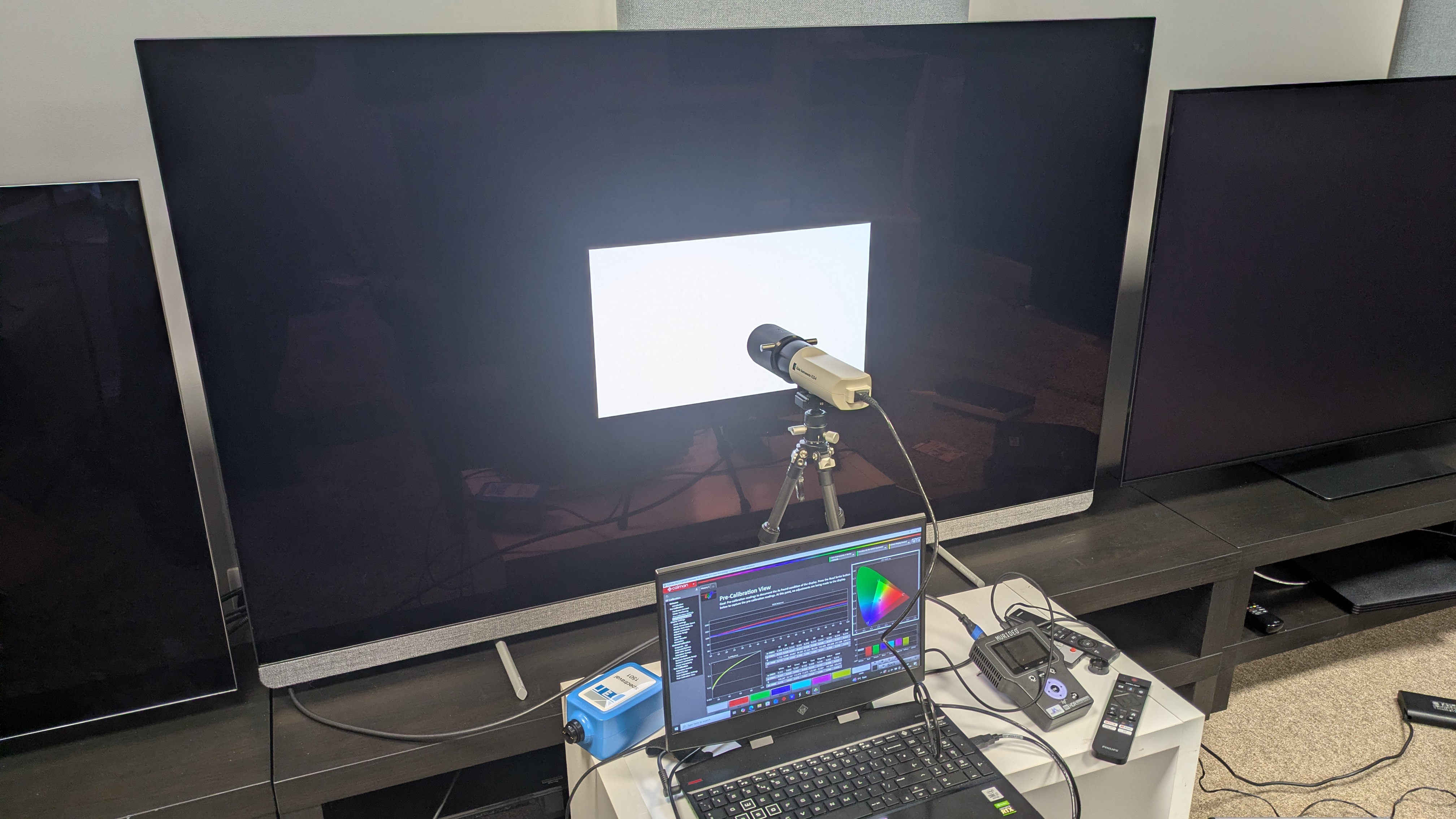 Philips OLED910 with testing equipment attached and white square on screen