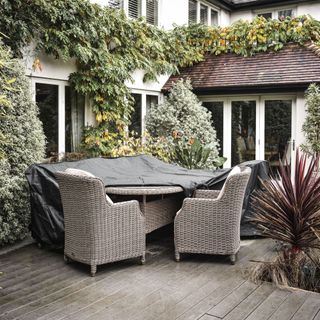 Patio with rattan chairs and table half covered