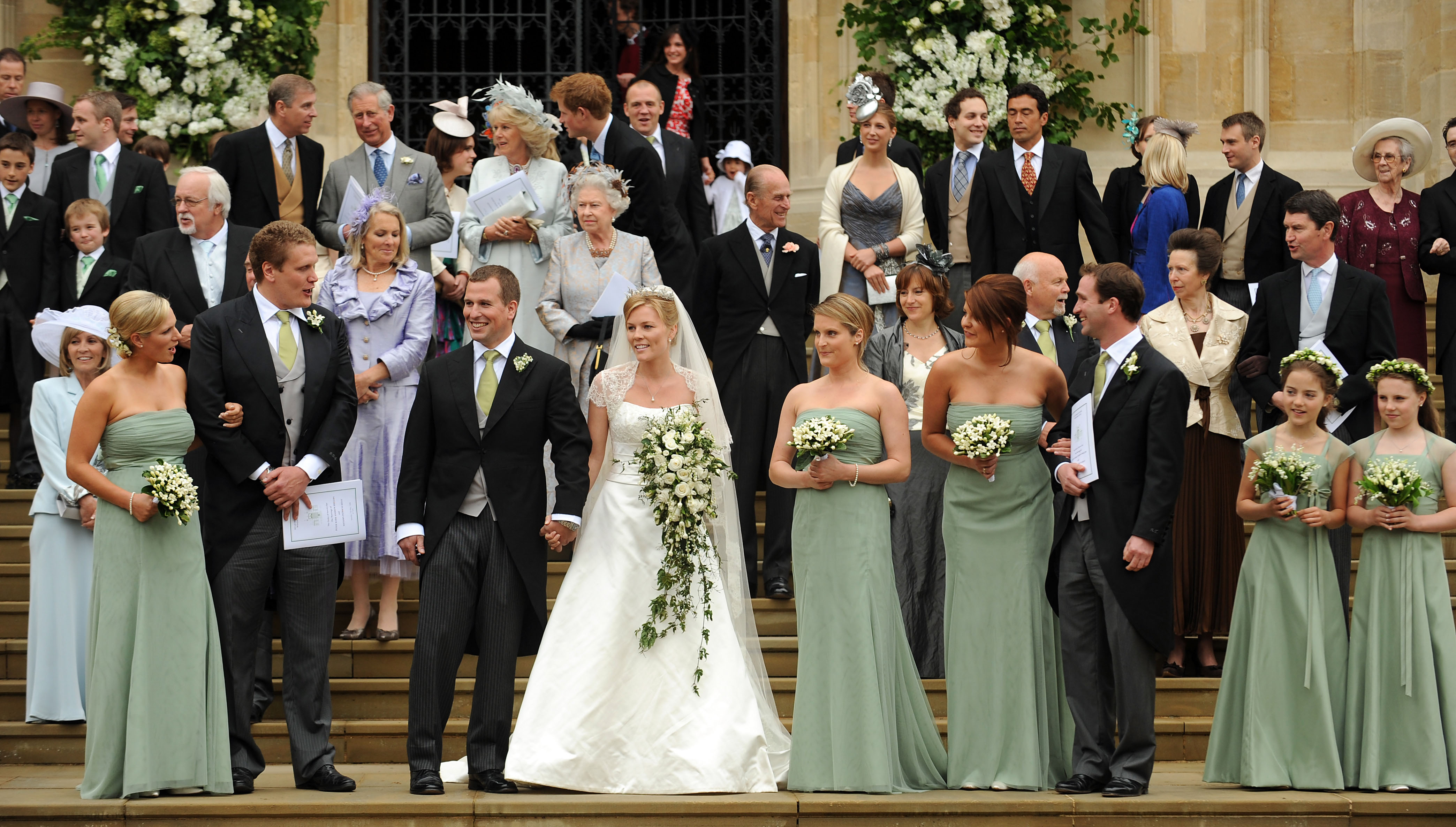 Peter Phillips and Autumn Kelly posing outside St George's Chapel on their wedding day with the bridal party
