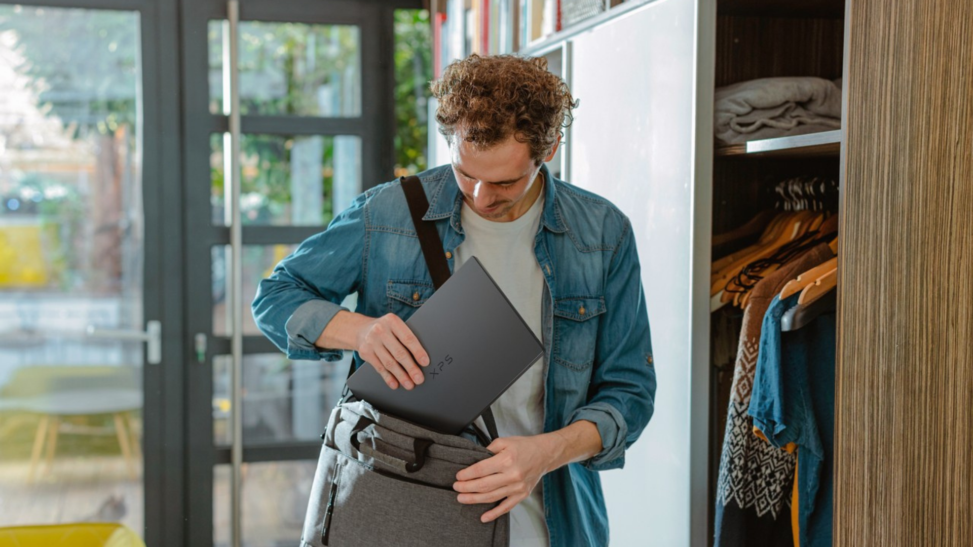 Man putting the Dell XPS 14 in his bag