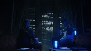Max og Lucas sitter rolig i mørket ved siden av et blått lys i «Stranger Things» sesong 4 volume 2