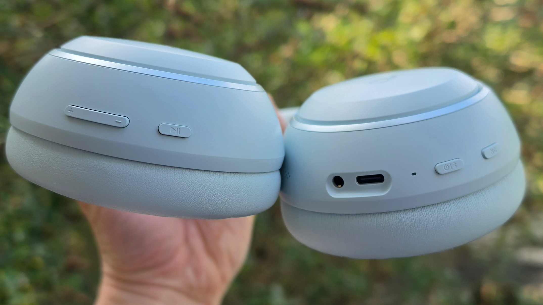 The Soundcore Space 2 in front of a green bush.