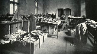 Solomon Schechter studies boxes of manuscripts from the Cairo Genizah.