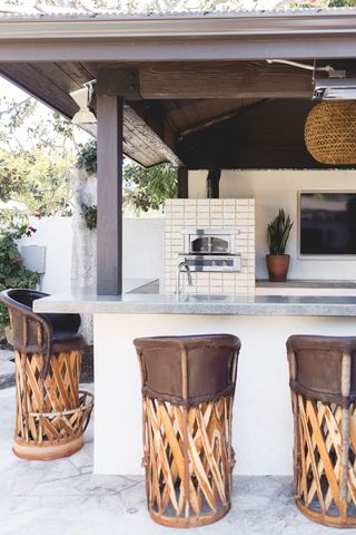 An outdoor kitchen with tall bar stools