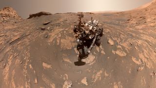 a large rover on a rocky reddish surface