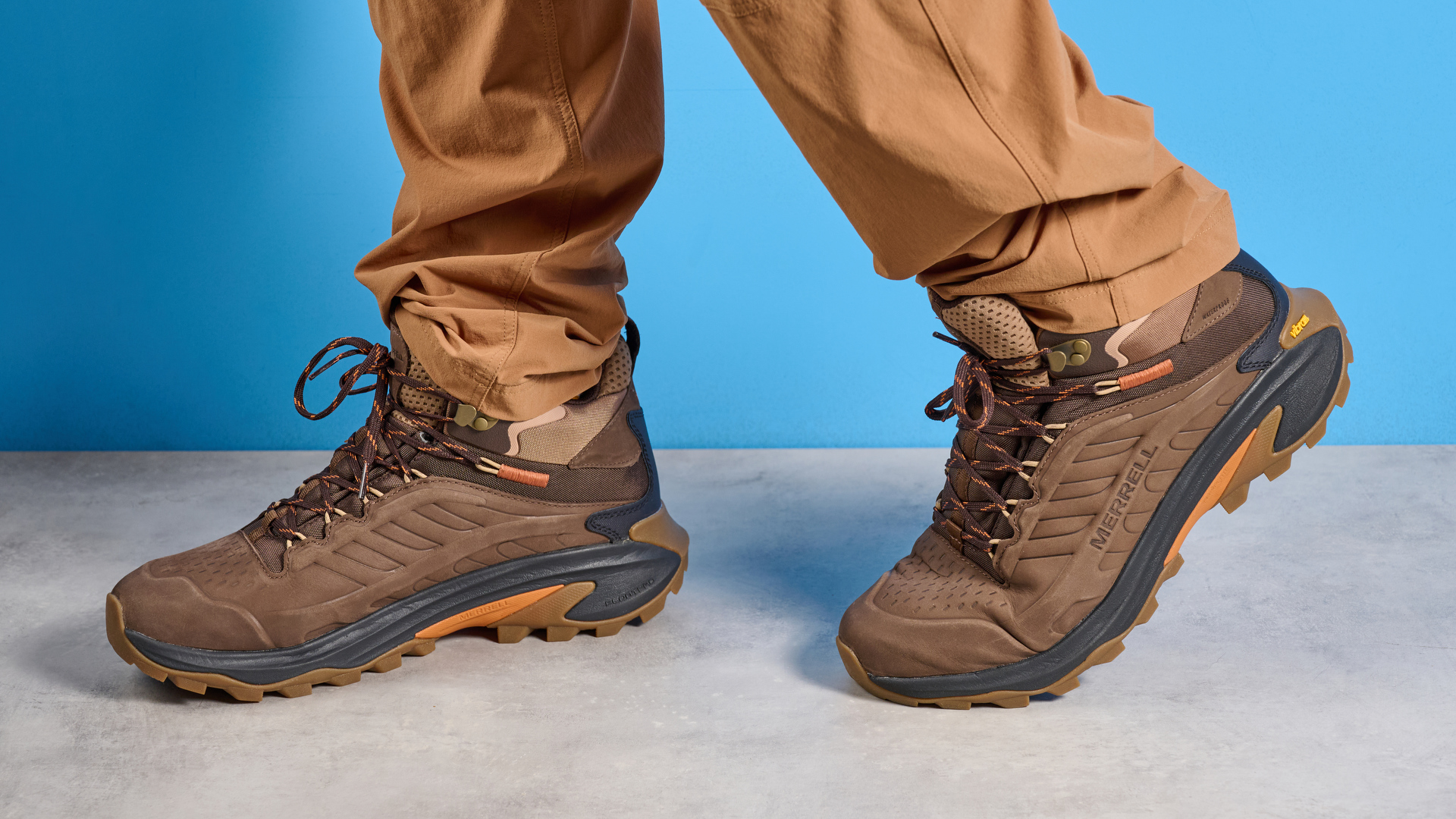 A photo of the Merrell Moab Speed 2 boots against a blue background
