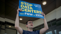 a protester holding a 'stop data centers' sign