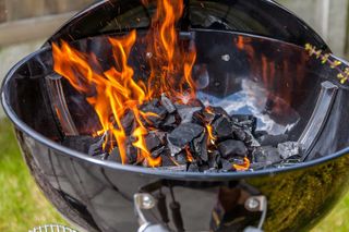 close-up image of lit charcoal on bbq