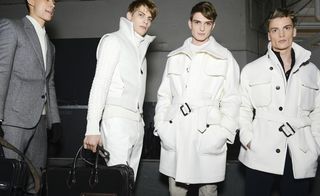 Male models posing in long rain jackets
