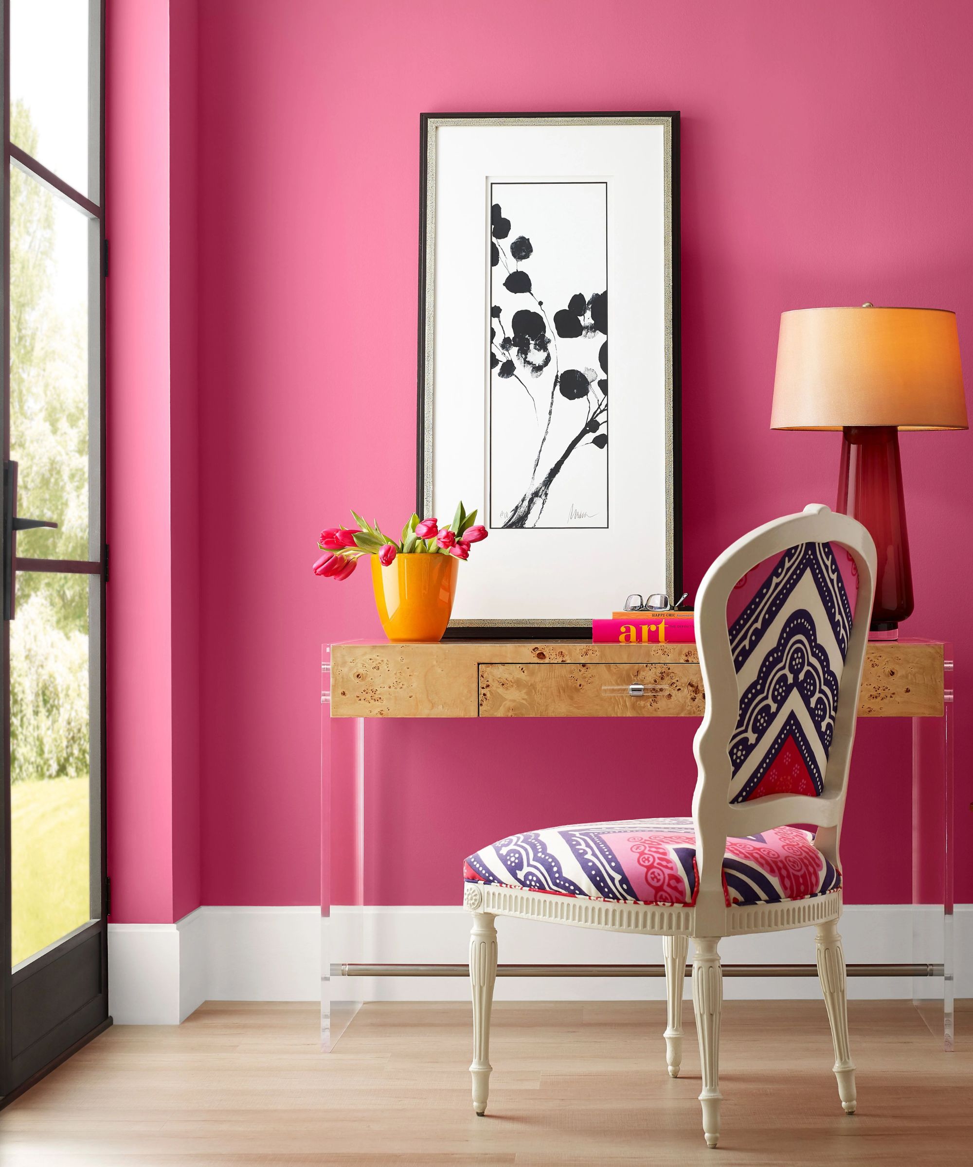 a bright pink room painted in Sherwin Williams' Dragon Fruit with french doors and a burl wood desk