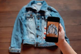 Taking a photo on a mobile phone of a denim jacket