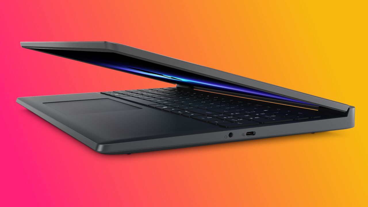 A sleek, partially open black laptop is shown against a vibrant orange and pink gradient background, highlighting its modern design and slim profile.