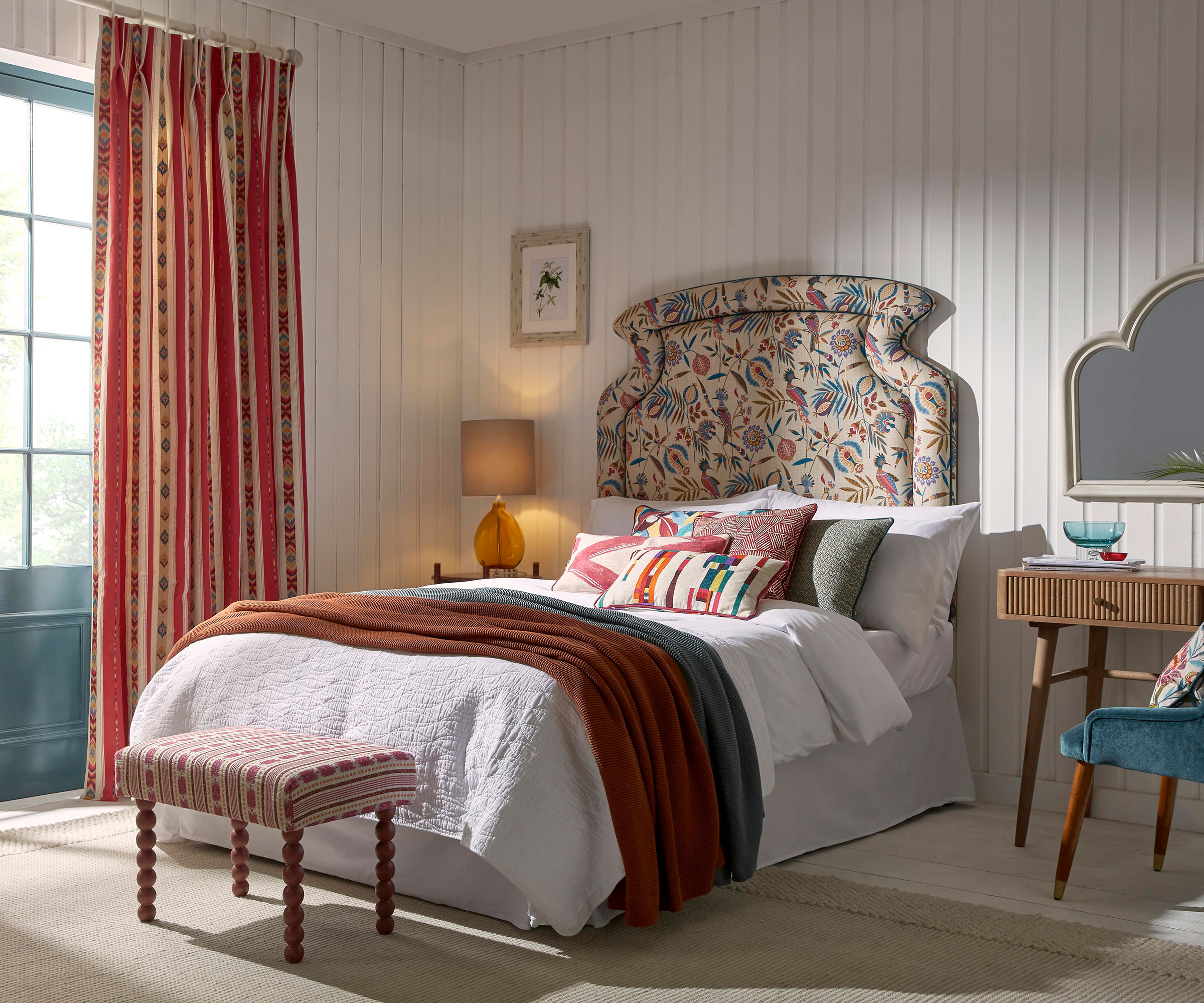 master bedroom with upholstered floral headboard and layers of fabrics