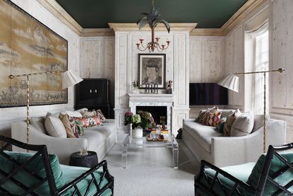 living room with white wood panels and grey sofas