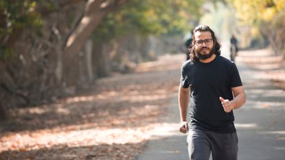 man with beard and glasses walking in the park