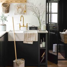 Utility room with black cabinets and mop and bucket