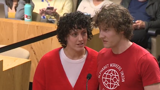 An image of two workers from Google YouTube at the plinth in the city of Austin, Texas. One unionised worker has just finished delivering his speech when his colleague appears to inform him of his team's layoffs.