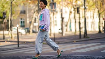 stylish woman wearing trendy gray sweatpants and green heels