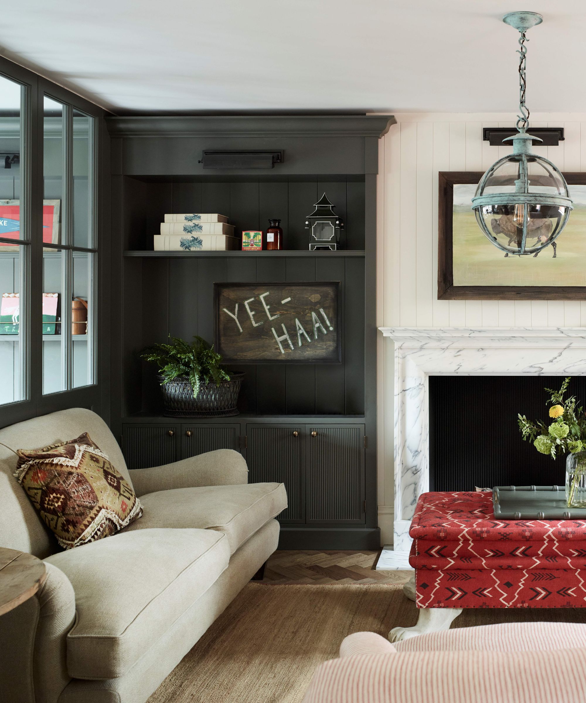 Living room with grey alcoves and dark red ottoman