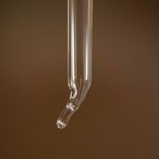 A glass dropper with clear liquid